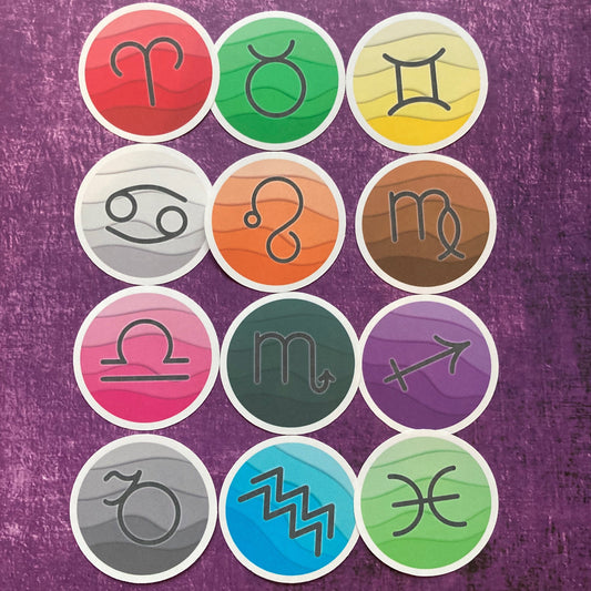 A grid of 12 vibrant circular stickers from the Zodiac Stickers (Copy) collection by Crafted By Colette, each featuring a unique astrological zodiac symbol on a textured purple background. The symbols are presented in an array of colors including red, green, yellow, gray, orange, brown, pink, dark green, violet, light gray, blue, and turquoise.